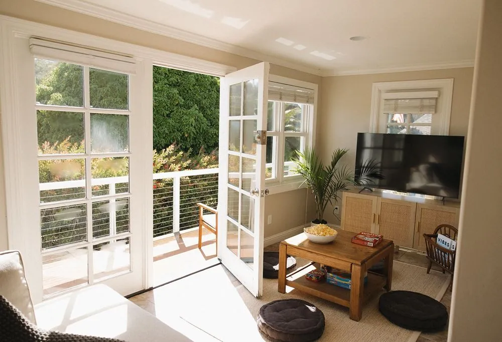 Lower living room with French doors open to the creek